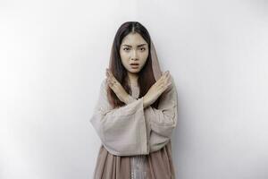schön asiatisch Muslim Frau tragen ein Hijab mit Hand Geste Pose Ablehnung oder Verbot mit Kopieren Raum foto