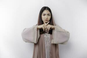 schön asiatisch Muslim Frau tragen ein Hijab mit Hand Geste Pose Ablehnung oder Verbot mit Kopieren Raum foto