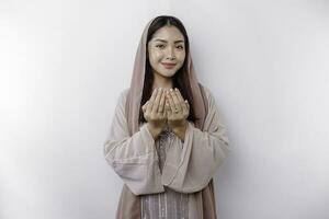 religiös schön asiatisch Muslim Mädchen tragen ein Kopftuch beten zu Gott, isoliert durch Weiß Hintergrund foto