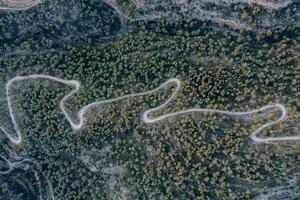 Antenne Schuss von ein kurvig Straße auf ein Berg im ein Wald foto