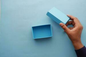 oben Aussicht von Person öffnen ein leeren Blau Farbe klein Geschenk Box foto