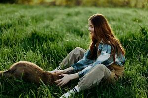 Frau Spiel mit ihr Hund im Natur lächelnd und Lügen auf das Grün Gras im das Park, glücklich gesund Beziehung zwischen Herrin und Haustier foto