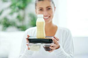 jung Frau auf Bett mit Essen Gastronomie Box foto