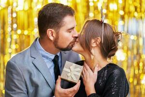 Paar mit Gold Geschenk auf Neu Jahr oder Weihnachten Party foto