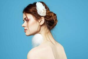 glamourös Frau mit flauschige Ohrringe hell bilden klar Haut Blau Hintergrund foto