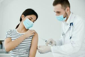 männlich Arzt spritzt Impfstoff Patienten Schulter Gesundheit Coronavirus foto