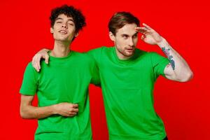 heiter freunde im Grün T-Shirts Umarmungen Kommunikation positiv foto