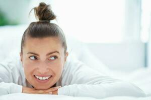 nett weiblich im Bett entspannend oder tun Yoga foto