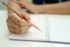 asiatisch Teenager Schüler schreiben Hausaufgaben, Studie Lektion zum Prüfung online Lernen Bildung. foto