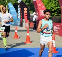 Neu Delhi, Indien - - April 16 2023 - - Vedanta Delhi Hälfte Marathon- Rennen nach covid im welche Marathon- Teilnehmer Über zu Kreuz das Fertig Linie, Delhi Hälfte Marathon- 2022 foto