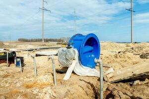 verbinden ein Graben ablassen zu ein Beton Mannloch Struktur beim Konstruktion Seite? ˅. Beton Stapel im Schalung Rahmen zum konstruieren Regenwasser und unter Tage Dienstprogramme, Pumpe Stationen, Kanalisation Rohre foto