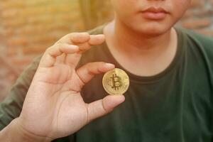 schließen oben von Bitcoin ist gehaltenen durch Mann mit verwischen Hintergrund. Kryptowährung Handel Konzept. selektiv Fokus Bild foto