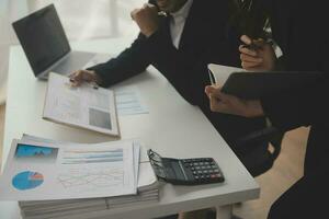 finanzanalysten analysieren während einer diskussion auf einem unternehmenstreffen geschäftsfinanzberichte zu einem investitionsprojekt zur planung digitaler tabletten und zeigen die ergebnisse ihrer erfolgreichen teamarbeit. foto