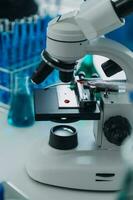 Mikroskop mit Labor Glaswaren, Wissenschaft Labor Forschung und Entwicklung Konzept foto