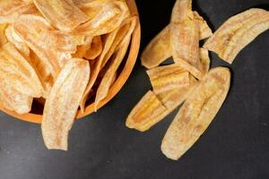 Banane Chips mit ein Süss und salzig Geschmack gemacht von gebraten roh Bananen im ein hölzern Schüssel. traditionell Snacks foto