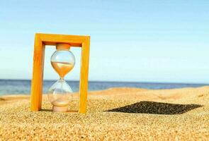 ein Sanduhr auf das Sand foto