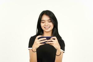 lächelnd und spielen Handy, Mobiltelefon Spiel auf Smartphone von schön asiatisch Frau isoliert auf Weiß Hintergrund foto
