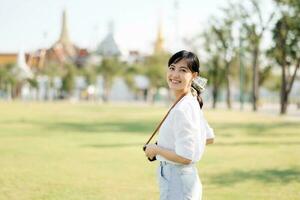 Porträt schön jung asiatisch Frau auf Sommer- Urlaub Ferien Ausflug mit das großartig Palast im ein Hintergrund beim Bangkok, Thailand foto