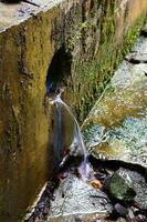 Abwasser fließend im moosig schmutzig Gräben foto