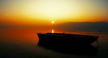 schön Ozean mit ein klein Boot schwebend auf Wasser beim Sonnenuntergang foto