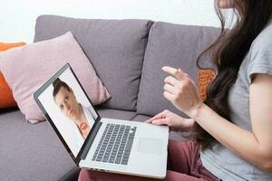 Berufung ein Arzt online, Behandlung mit Telemedizin. ein Frau berät mit ein Arzt online mit Laptop foto