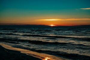 malerisch Ruhe Sonnenuntergang mit bunt Wolken auf das Ufer von das baltisch Meer im Polen foto