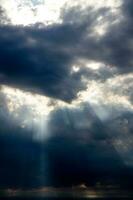 bedrohlich dramatisch Himmel mit dunkel Wolken und Strahlen von Sommer- Sonne foto