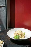 Italienisch Pasta auf schwarz Cafe Zähler Nächster zu das Fenster, haben Mittagessen foto