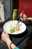 Frau Essen Italienisch Pasta Sitzung beim das Cafe Zähler suchen zu das Fenster, haben Mittagessen foto