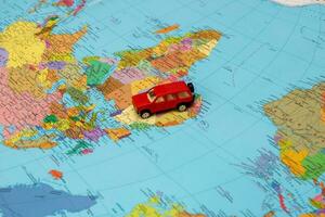 klein Spielzeug Auto auf das politisch Karte von das Welt foto
