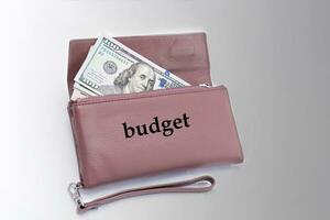 Budget Brieftasche mit 100 Dollar Rechnungen auf ein grau Hintergrund. foto