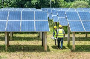 Ein Team männlicher Ingenieure ist dabei, Solarmodule zu installieren. beim Solarkraftwerk Ingenieurteam bestellte und installierte Solarzellen. foto