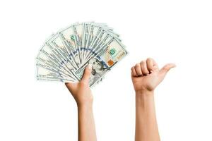 isoliert Bild von Dollar im einer Hand und zeigen Daumen oben Geste mit Ein weiterer Hand. oben Aussicht von Geschäft Konzept foto