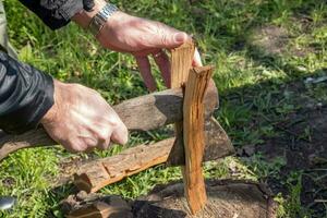 ein Mann ist Hacken Holz zum ein Zuhause Kamin. Ferien Konzept im das Landschaft foto