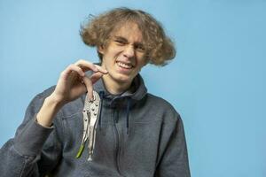 Festsetzung Zange eingeklemmt das Finger von ein Teenager mit wellig Haar foto