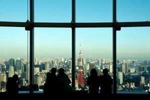 Menschen Sitzung im das Terrasse suchen zum Tokyo Turm foto