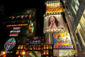 Osaka, Japan, 2018 - - japanisch Werbung Bretter von Vielfalt Produkte auf Gebäude beim shinsaibashi und Dotonbori Einkaufen Straße mit bunt Neon- und Plakatwand Beleuchtung auf Nacht Zeit. foto