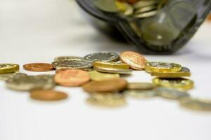 Nahansicht Stapel von britisch Währung Münzen öffnen von das Schweinchen Bank gelegt aus verstreut auf Weiß Hintergrund. foto