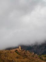 schön dramatisch Landschaft Natur Aussicht im das Berge. alt ossetisch Schlacht Turm im das neblig Berge. Digoria Region. Norden Ossetien, Russland. Vertikale Sicht. foto