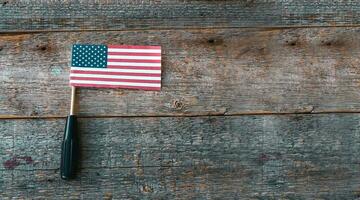 amerikanisch Flagge und ein Schraubendreher Pailletten auf ein hölzern Hintergrund, eben legen. ein Urlaub im amerika.glücklich Arbeit Tag. foto