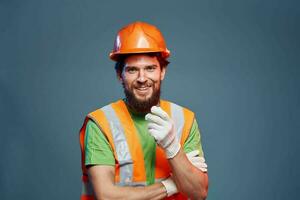 ein Mann im ein Arbeit Uniform ist ein Konstruktion Ingenieur. Industrie Fachmann Orange schwer Hut foto