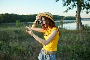 Frau Fotograf tragen Hut mit Kamera nimmt ein Bild von Natur foto