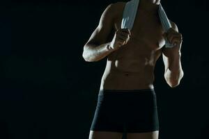 Mann mit muskulös Abs abgeschnitten Aussicht von Fitnessstudio dunkel Hintergrund foto