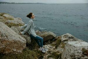 ziemlich Frau Pullover wolkig Meer bewundern Natur Entspannung Konzept foto