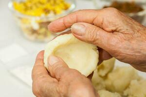 Vorbereitung Schritte von traditionell kolumbianisch Gericht namens ausgestopft Kartoffeln. kneten das püriert Kartoffeln durch Hand zu bilden ein Teig zum das ausgestopft Kartoffeln foto