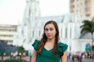 schön Tourist Mädchen beim das Ortiz Brücke mit la Ermita Kirche auf Hintergrund im das Stadt von cali im Kolumbien foto