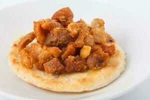 traditionell kolumbianisch Arepa gekrönt mit Schweinefleisch Rinde foto