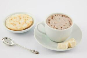 Tasse von heiß Schokolade mit Käse und Arepa serviert im Weiß Geschirr foto