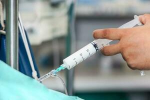 Krankenschwester spritzen ein Droge durch ein Infusion System foto