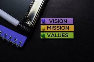 Vision, Mission, Werte Text auf klebrig Anmerkungen isoliert auf schwarz Schreibtisch. Mechanismus Strategie Konzept foto